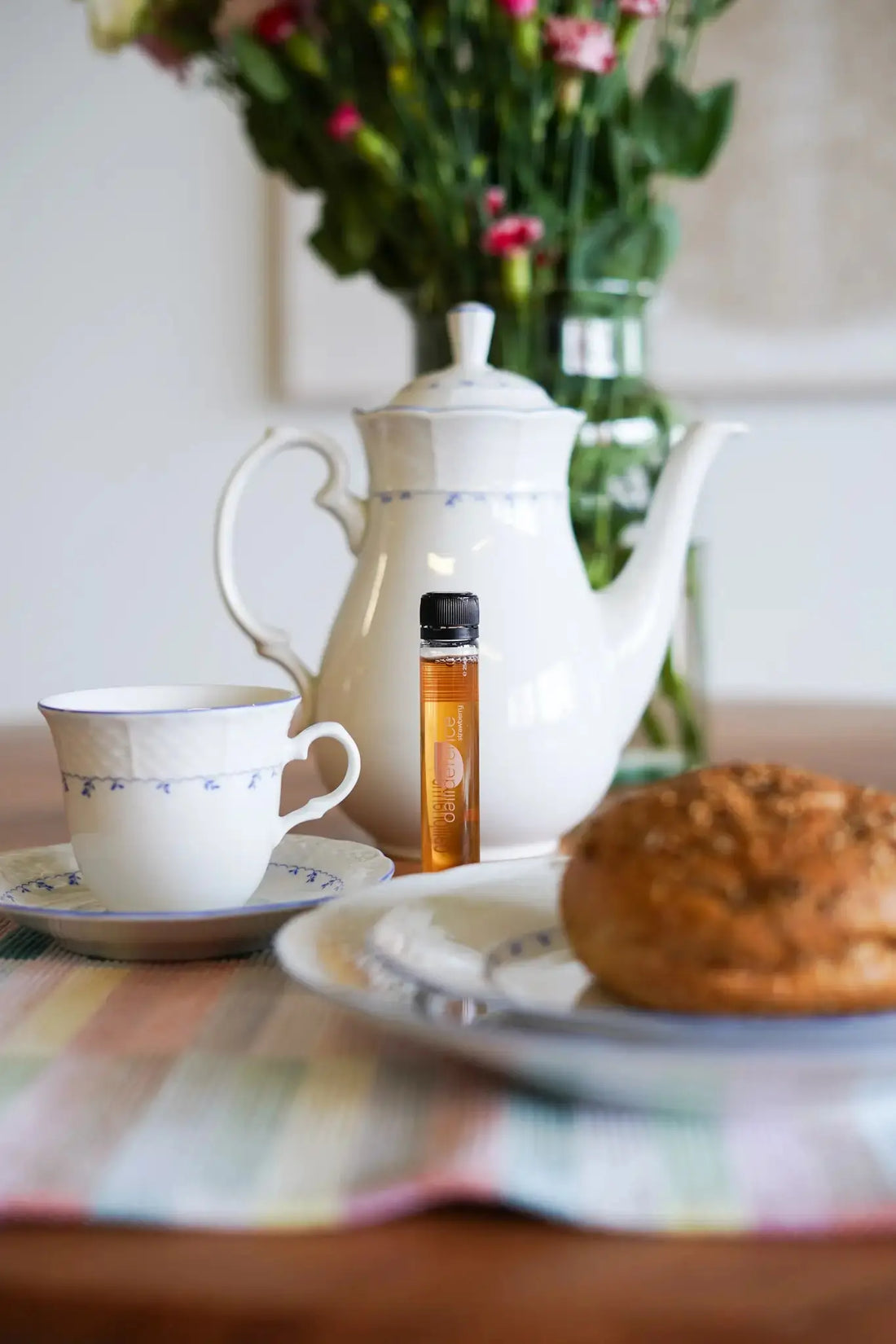 Dagelijkse supplementen in de ochtendroutine, afgebeeld als een vloeibaar shot naast een kop koffie en ontbijt.