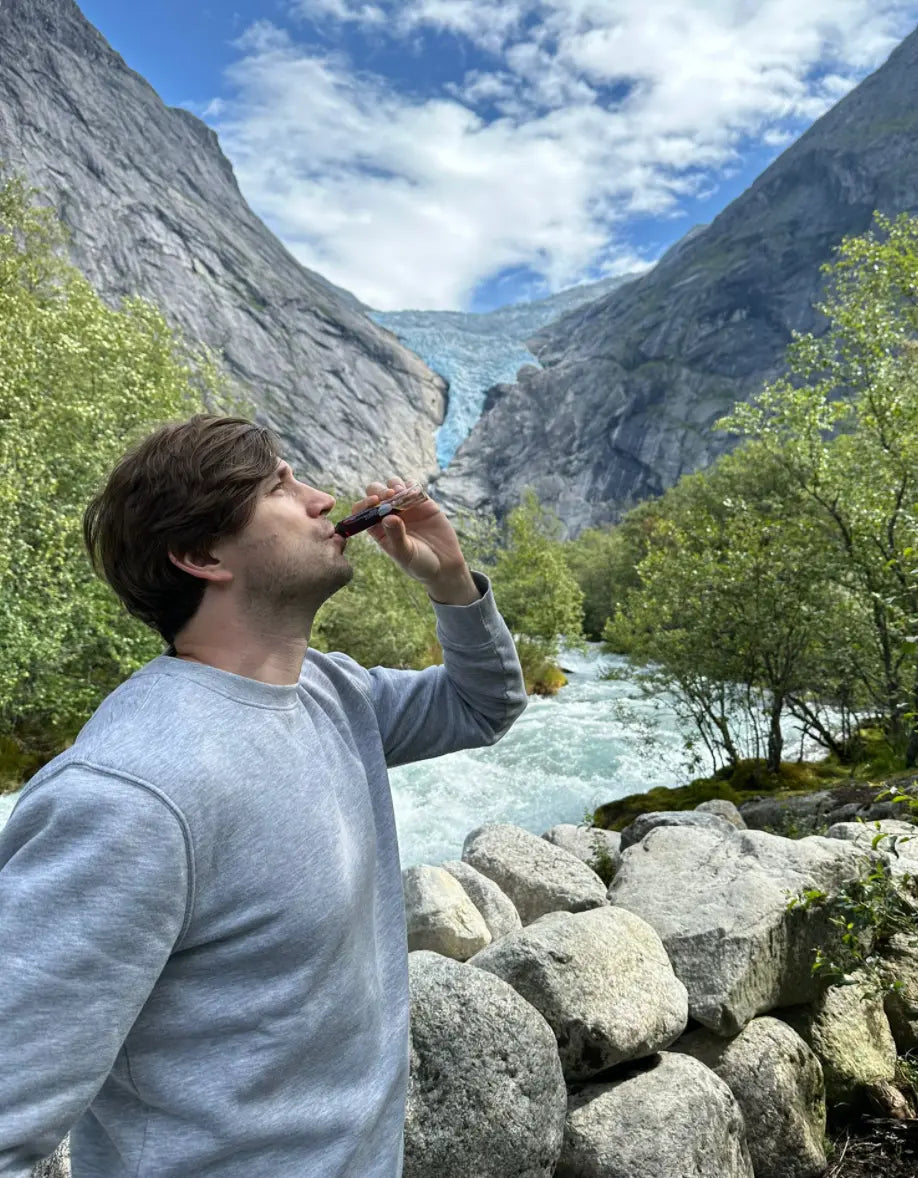 Dagelijks gebruik van een vloeibaar supplement in de natuur, passend binnen een bewuste levensstijl