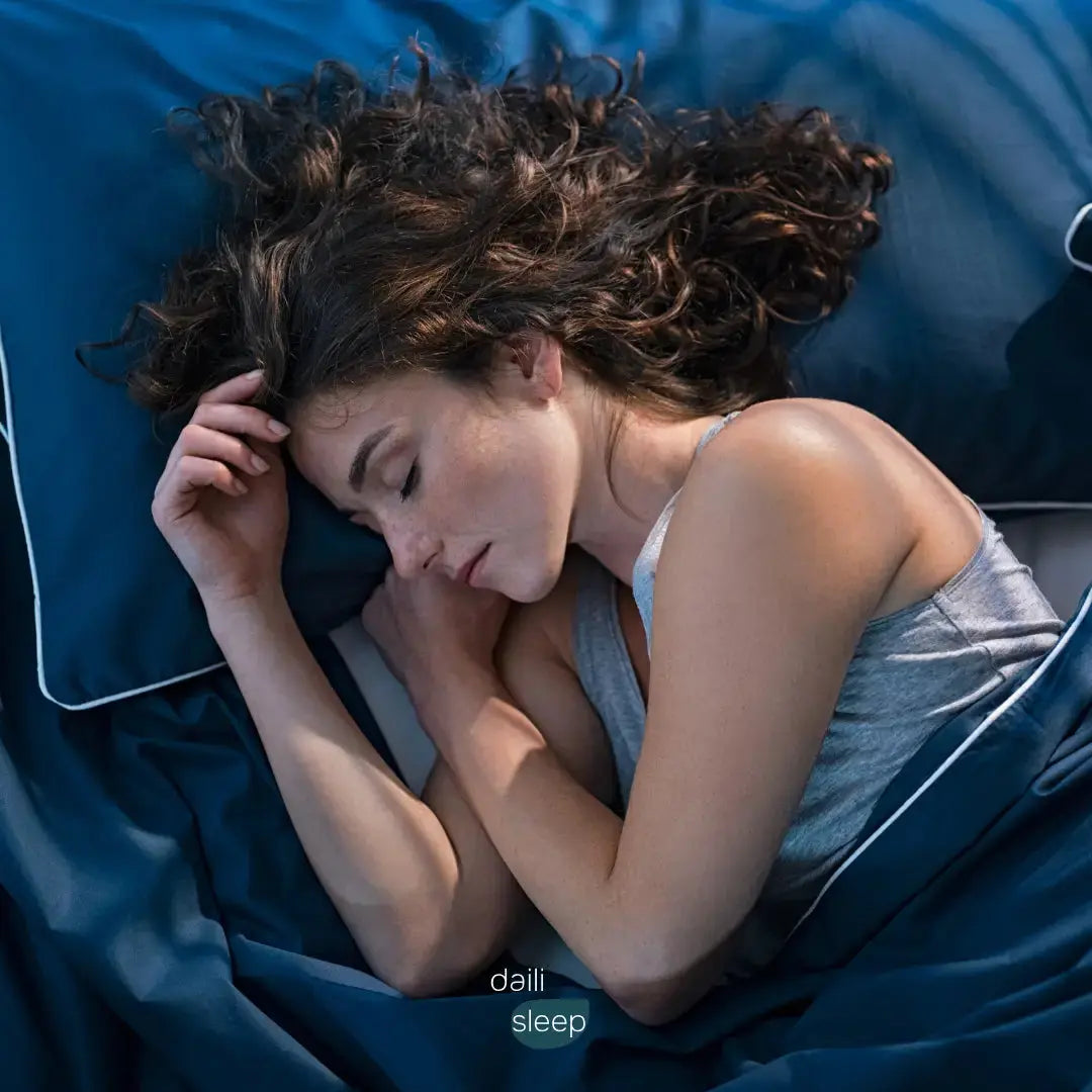 Vrouw slaapt rustig op haar zij in een blauw bed, symbool voor ontspanning en goede slaapkwaliteit.