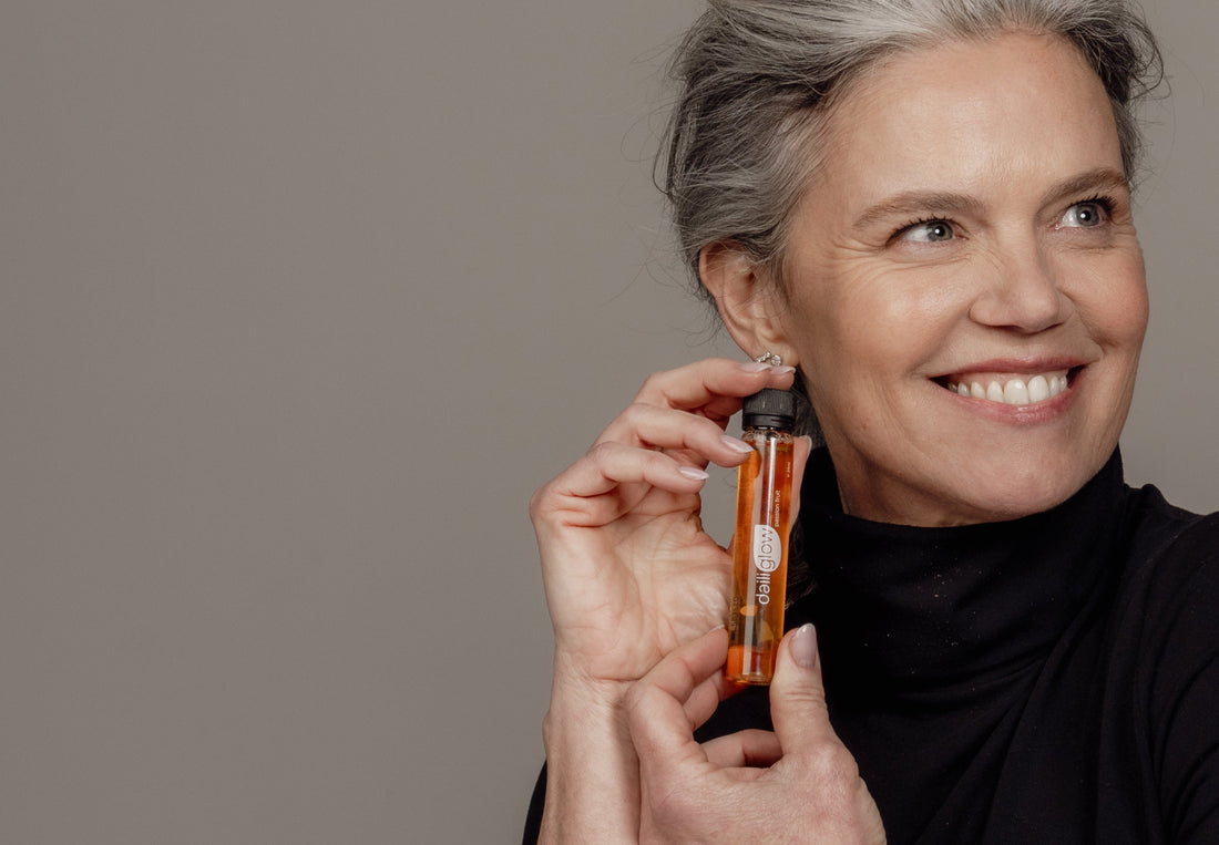 Vrouw houdt een flesje vloeibaar collageen vast als onderdeel van huidverzorging van binnenuit